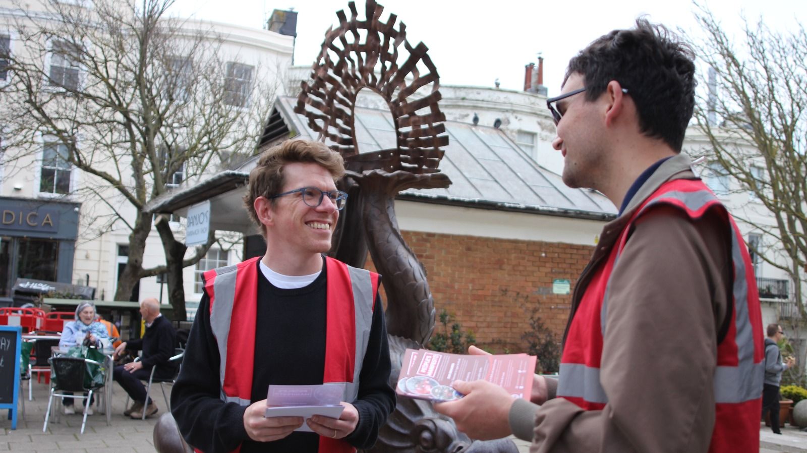 Picture of two ACORN members in fluorescent tabards promoting their manifesto outside Norfolk Square