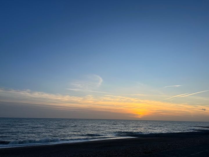 A nice orange sunset punctures the blue sky over the se