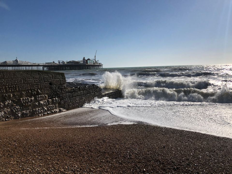 A picture of the waves crashing against a groyne on Brighton beach